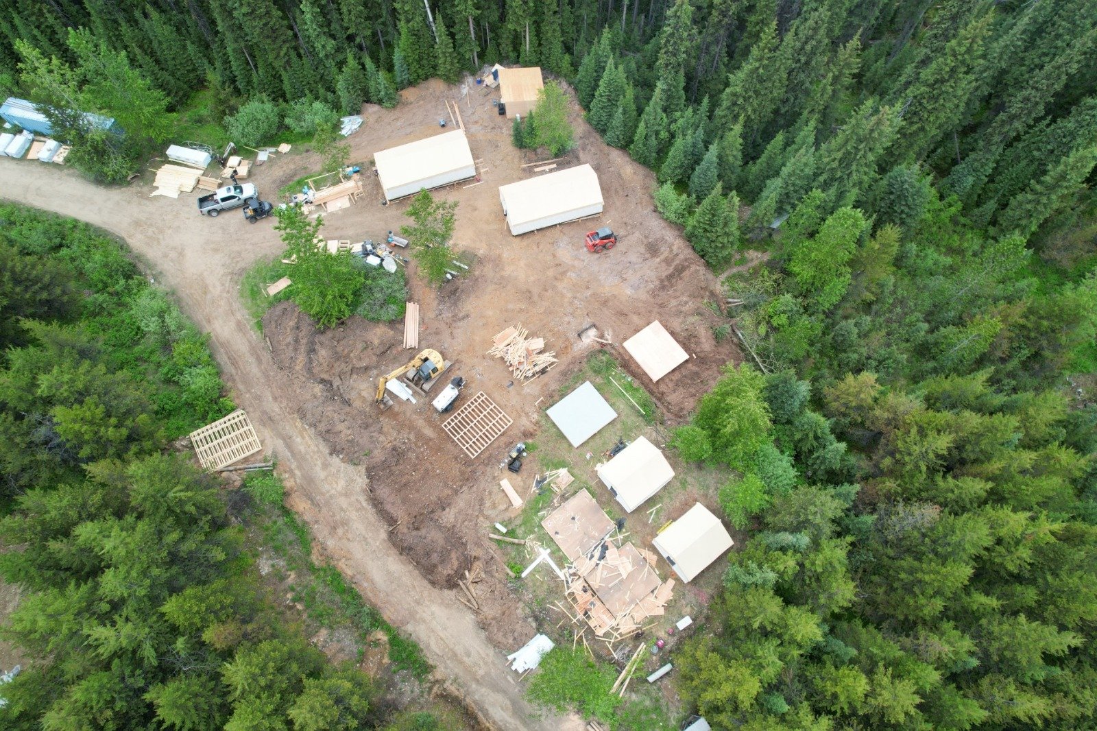Diamond drill rig operating at Fox Tungsten's exploration project in British Columbia with support buildings and mountainous forest landscape.